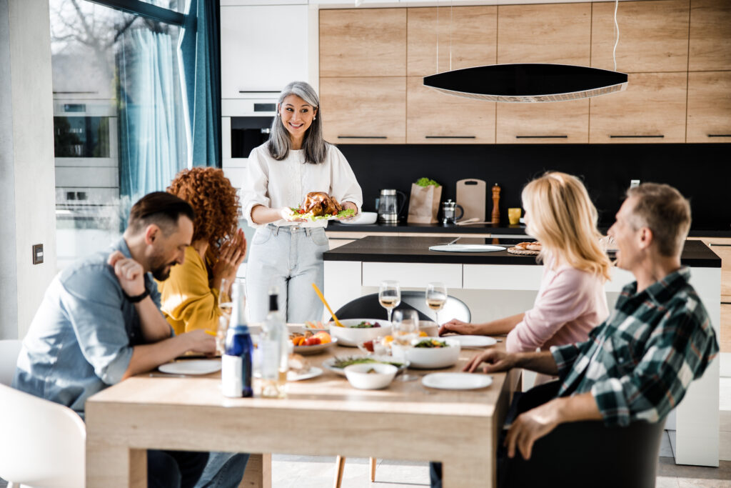 Friends and Family gathering around a dining table in a modern kitchen renovation.