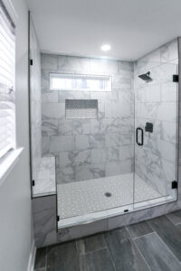 Marble shower with glass doors in a small bathroom remodel