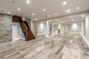 Large basement renovation with rustic wooden stairs and stone accents in a spacious open design.